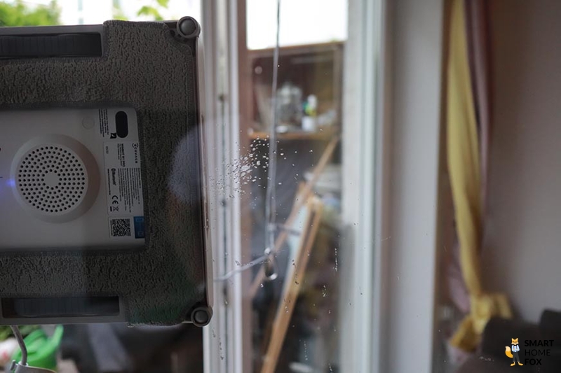 Es wird gezeigt, wie der Ecovacs Winbot W1 Pro die Scheibe mit Glasreiniger besprüht